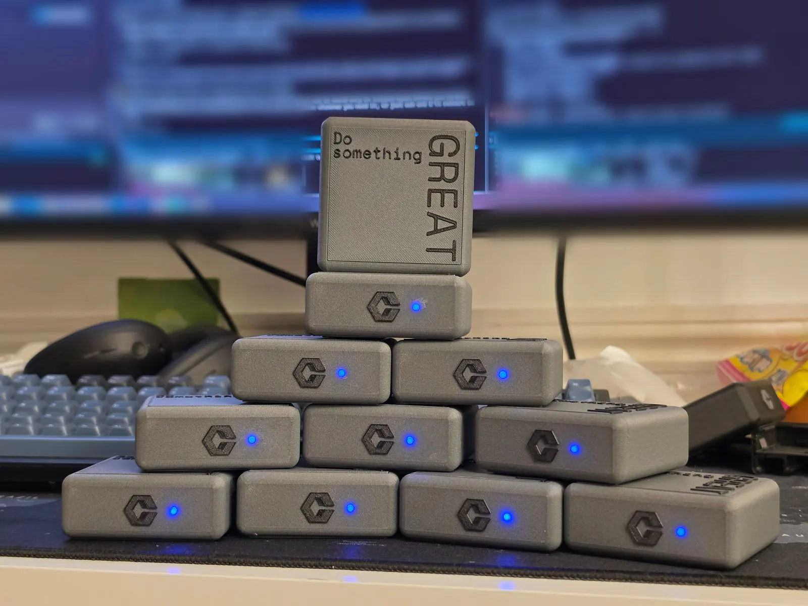 A pyramid of grey FocusField units with glowing blue status lights, topped by a cube embossed "Do something GREAT".